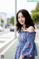 A woman in a blue floral dress posing for a picture.