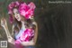 A woman in a blue dress holding a bunch of pink flowers.