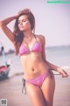 A woman in a bikini standing on a beach.