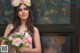 A woman in a pink dress holding a bouquet of flowers.