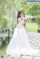 A woman in a wedding dress holding a bouquet of flowers.