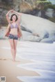 A woman in a bikini standing on a beach.