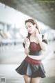 A woman in a black and red top and skirt posing for a picture.