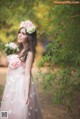 A woman in a pink dress holding a bouquet of flowers.