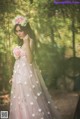 A woman in a pink dress with flowers in her hair.