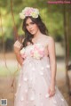 A woman in a pink dress with flowers in her hair.