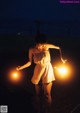 A woman holding a sparkler in her hands at night.