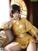 A woman in a yellow kimono sitting on a bed.