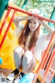 A woman sitting on top of a colorful playground slide.