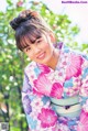 A woman in a pink and blue kimono posing for a picture.