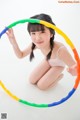 A young woman is playing with a hula hoop.