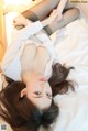 A woman laying on top of a bed wearing black stockings.