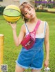 A young woman holding a basketball in her hand.