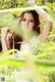 A woman in a white dress standing in tall grass.