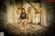 A woman in a black and white lingerie posing in an abandoned building.