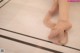 A woman's feet in a pair of ballet shoes on a tiled floor.