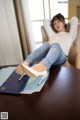 A woman sitting on top of a table next to a book.